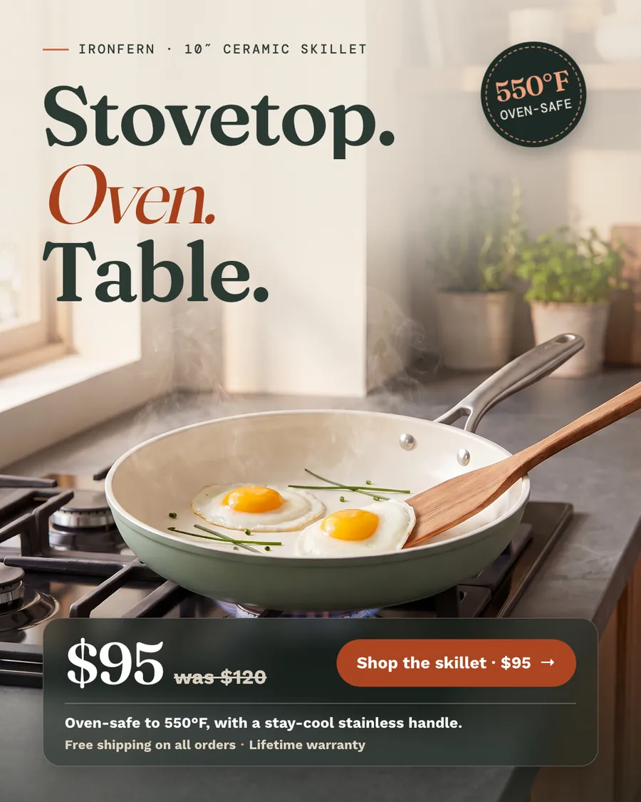 Cream and sage kitchen photo Ironfern ad: 'Stovetop. Oven. Table.' above a sage green skillet on a gas burner with two fried eggs and a wooden spatula, a 550°F oven-safe badge, $95 was $120, and a 'Shop the skillet · $95' button.