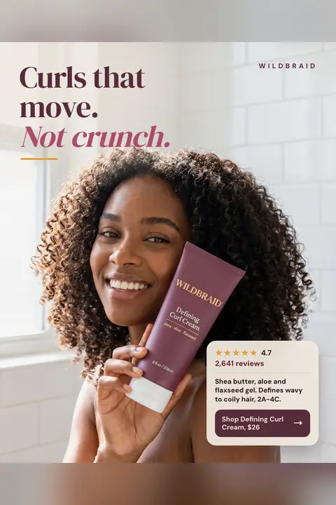 Soft white tiled bathroom look, Wildbraid ad: 'Curls that move. Not crunch.' A smiling woman with voluminous curly hair holds a plum Defining Curl Cream tube to her cheek. A card shows 4.7 stars, 2,641 reviews, and a 'Shop Defining Curl Cream, $26' button. Shown here in the 2:3 Pinterest size.